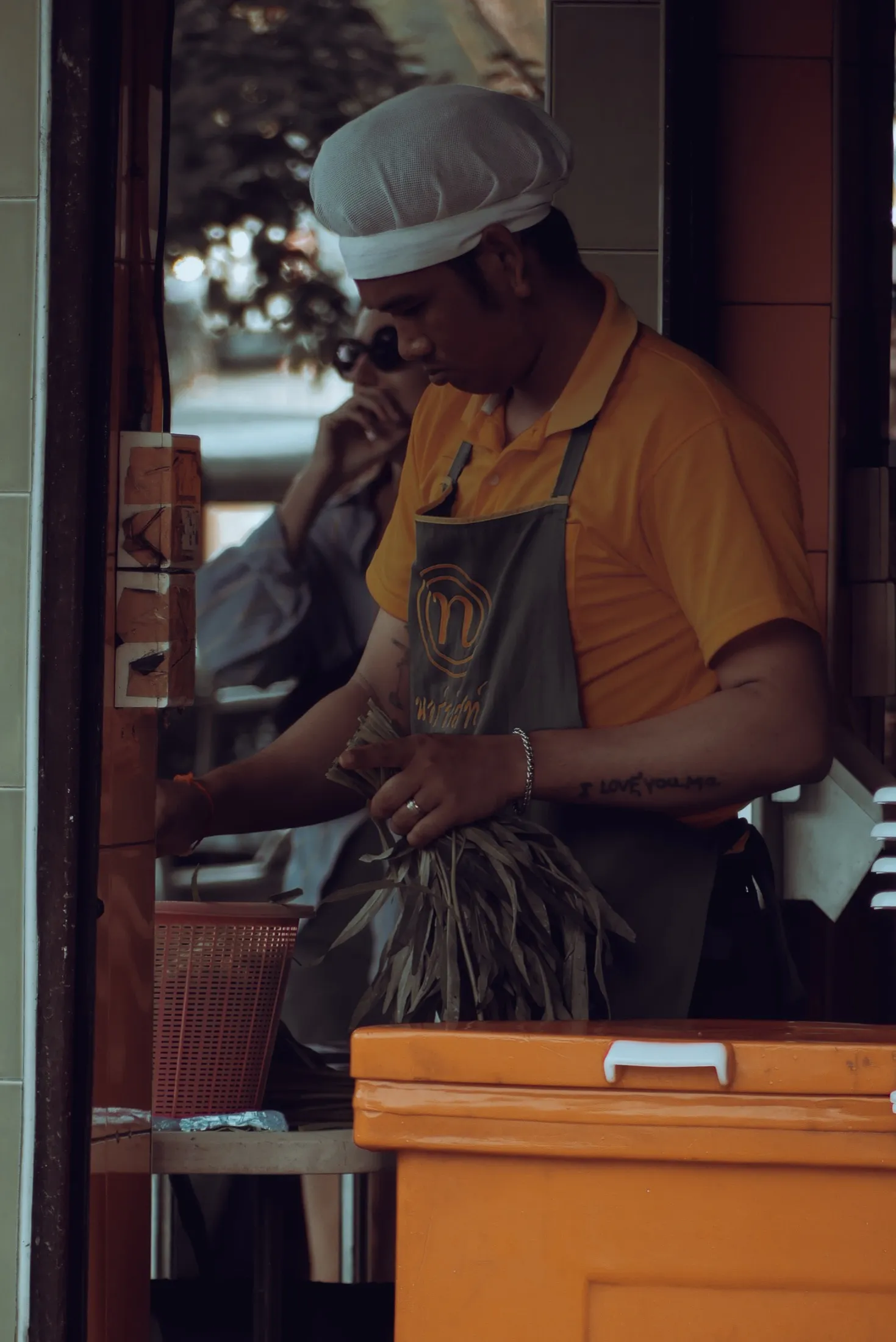 A food vendor works behind a small counter