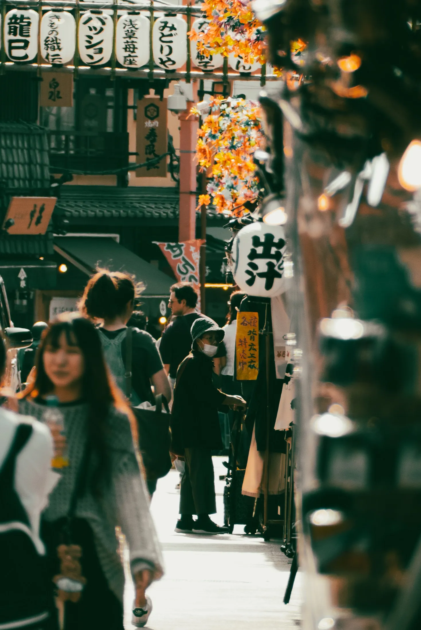 Pedestrians moving through a lantern-lined street
