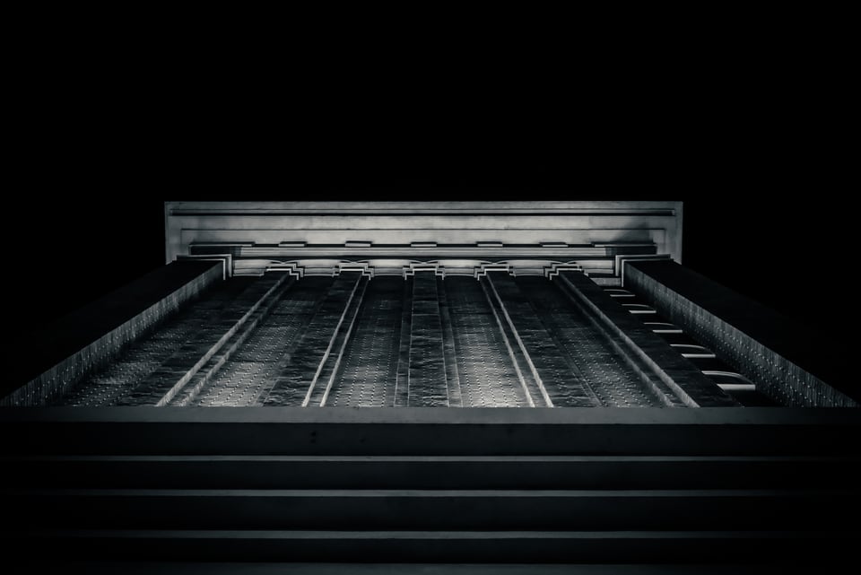A wide flight of steps and a dark colonnade lit at night.