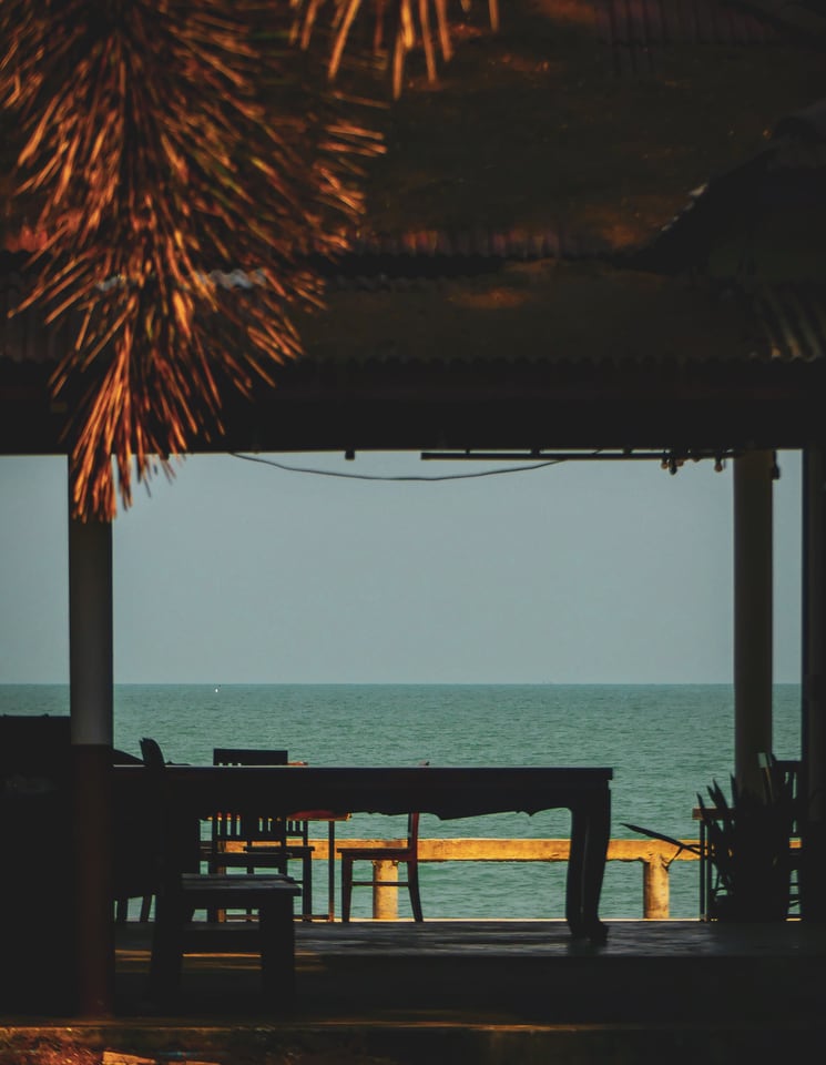 An open-sided shelter looks out over a flat grey sea.
