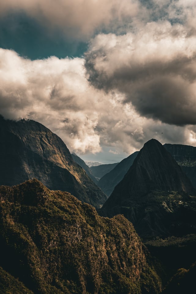 Steep green ridges fall away beneath a bank of low cloud.
