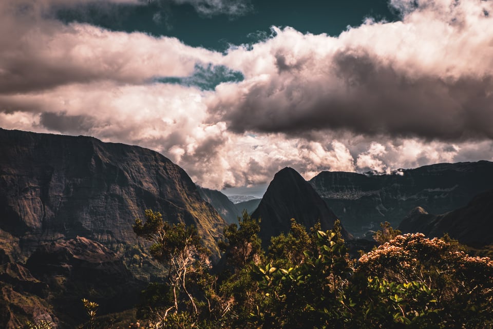 Cloud breaks over the ridges and pinnacles of a deep valley.