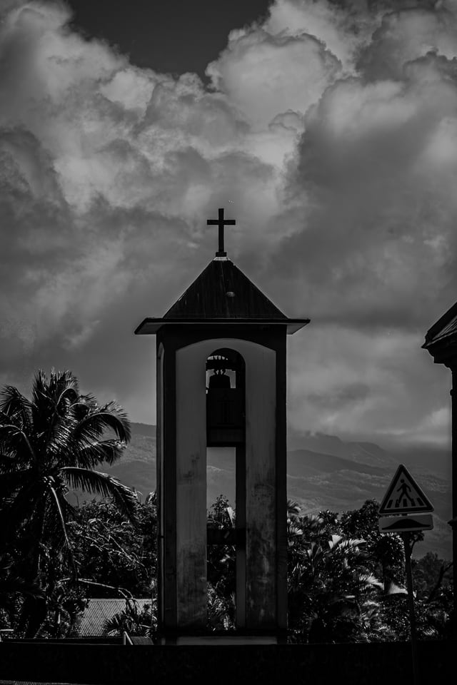 A small bell tower stands against piled cloud.