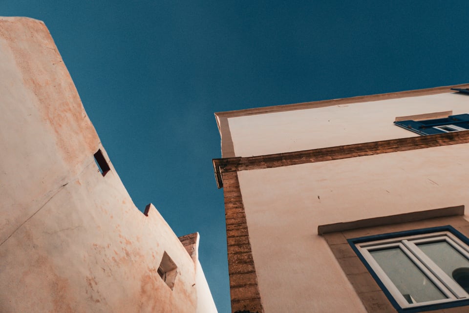 Two building corners meet against a deep blue sky.