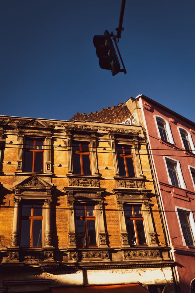 A traffic light hangs in front of an ornate nineteenth-century facade.