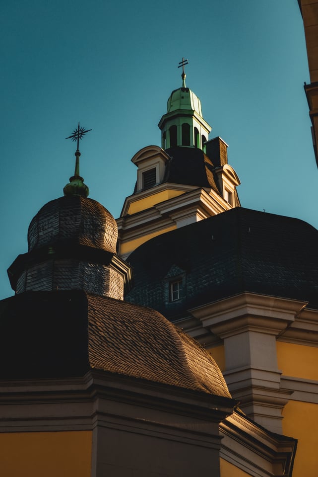 Church domes and a spire against a hard teal sky.